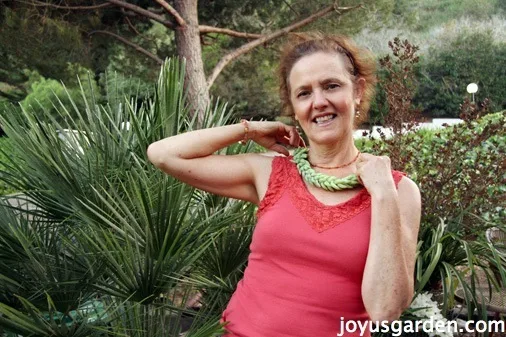 Nell holds a burros tail sedum succulent stem on her neck as if it was a necklace 