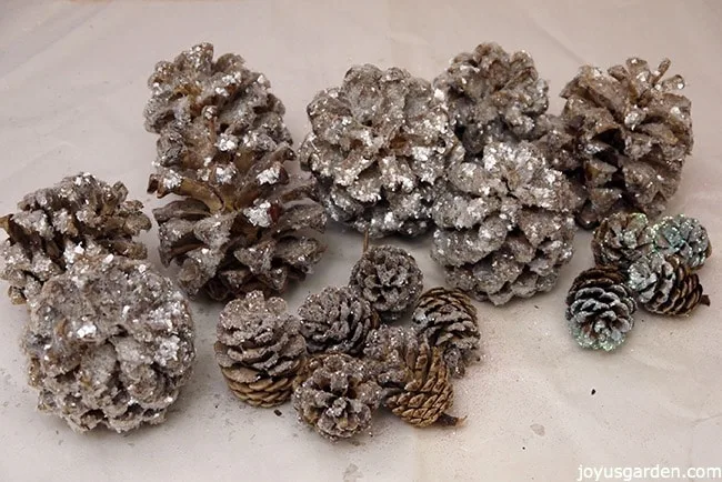 a grouping of many small to medium sized sparkly, crystal glitter pine cones