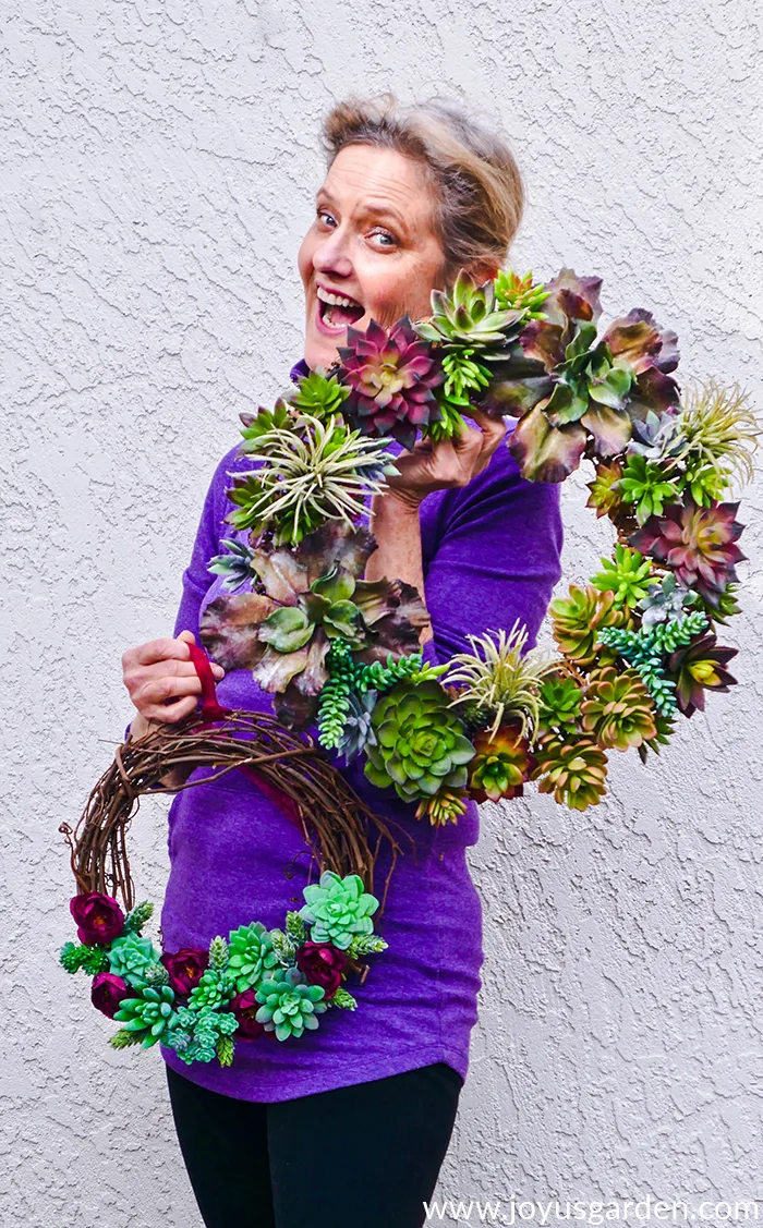 Nell Foster holding 2 DIY faux succulent wreaths she made