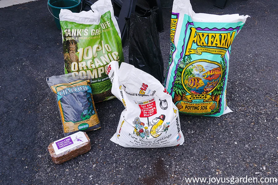 bags of ingredients to make up a soil mix for planting baby rubber plants sit in a driveway