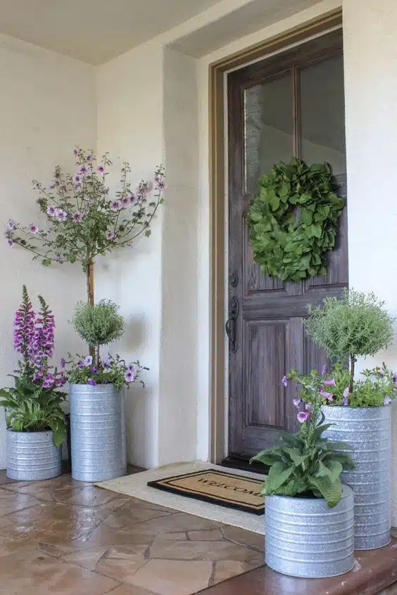 lavender flowers in planters on a front porch with welcome mat