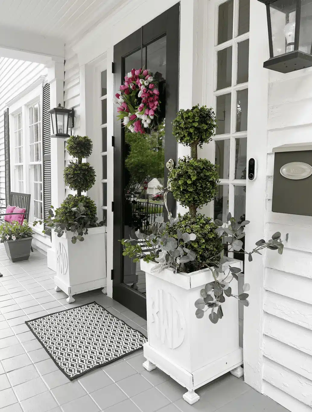 faux plants on front porch with tulip wreath