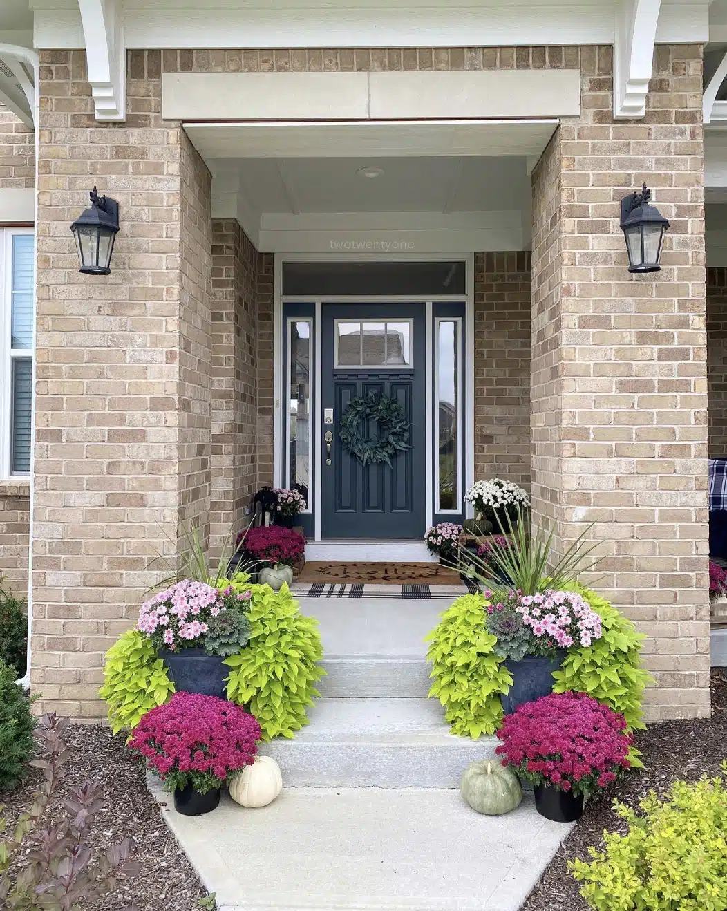 sweet potato vines and mums and pumpkins on a front porch