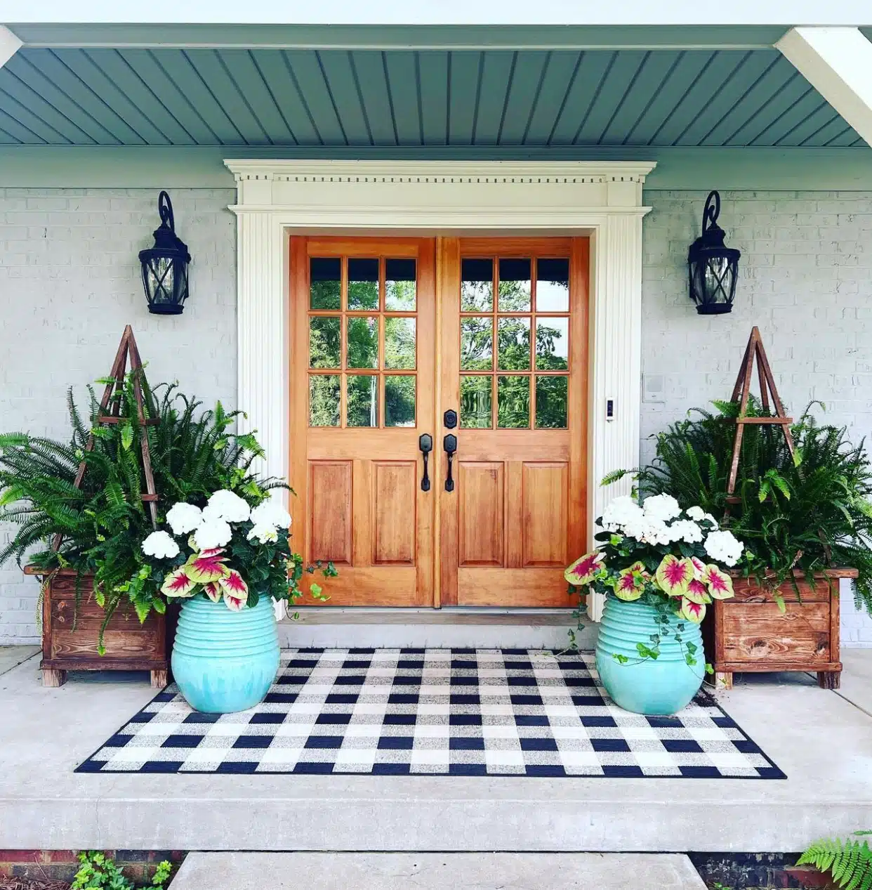 Boston ferns, coleus, and trailing ivy displayed on a front porch