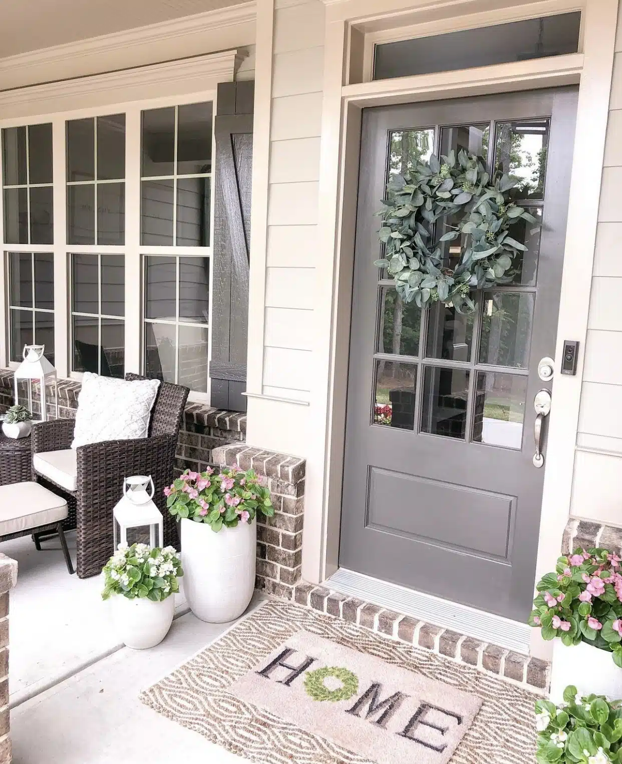 wicker patio furniture and flowers on a front porch